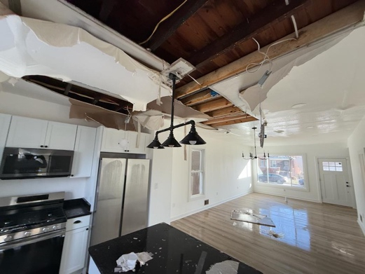 Kitchen and living room view of ceiling drywall damage due to flooding